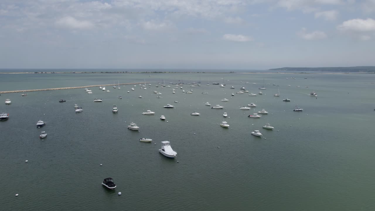 Aerial view over anchored boats on the coast of Plymouth, USA - reverse, drone shot