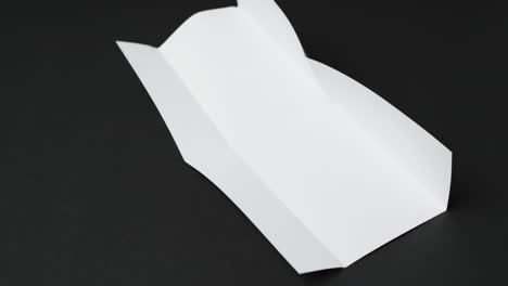 Video-of-piece-of-white-paper-with-creases-on-black-background