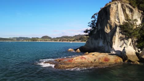 revealing from behind limestone cliffs to a bay in the coromandel peninsula