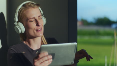 portrait of satisfied woman while listening to music on digital tablet