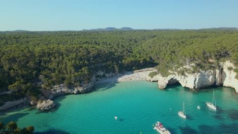 sailing yachts find a secluded beach to anchor off the coast of menorca