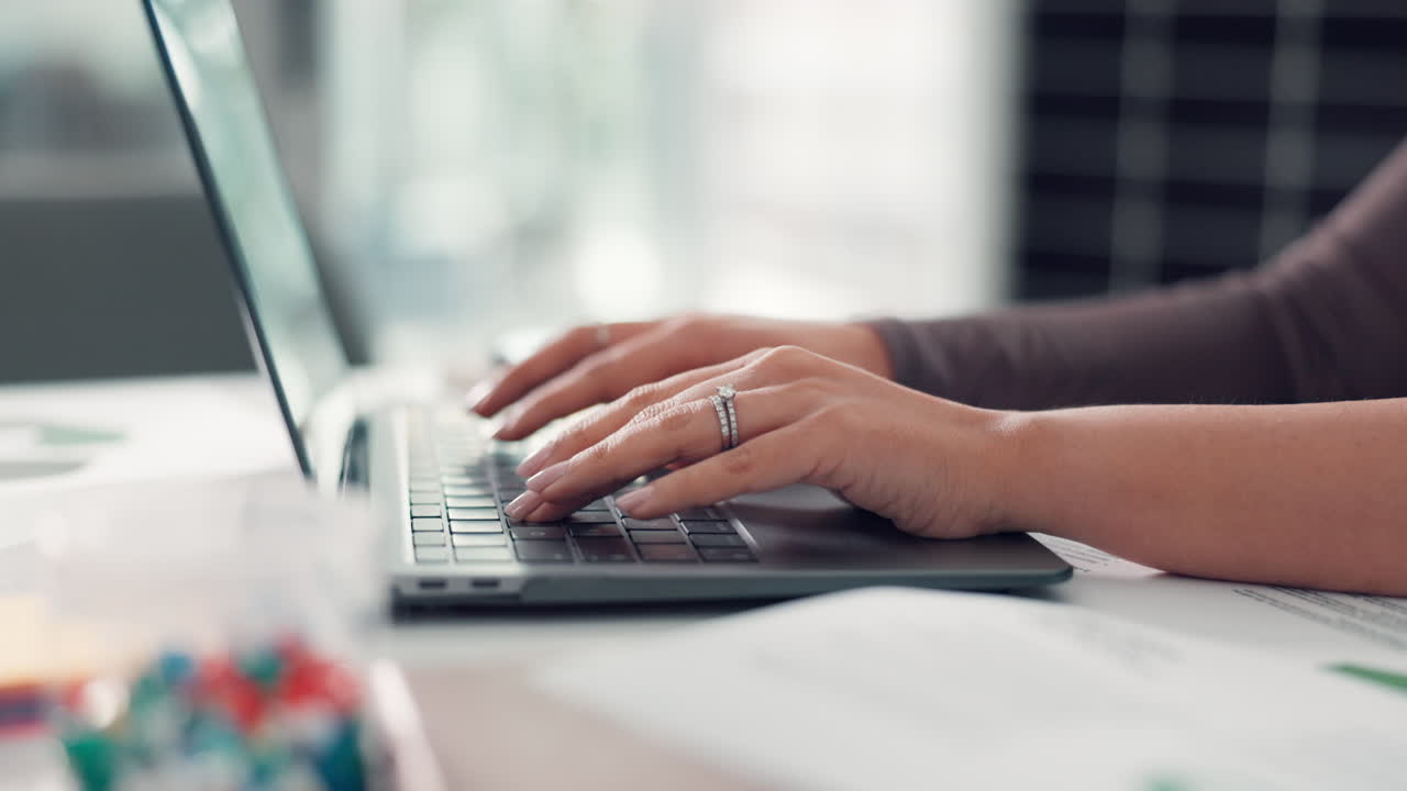 Close Up of Hands Typing on Laptop Keyboard at a Desk