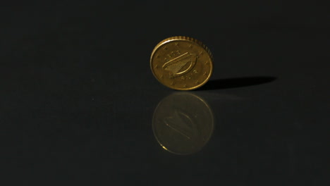 euro coin spinning on black surface