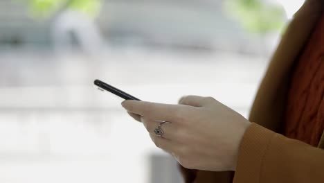 Toma-Recortada-De-Una-Mujer-Usando-Un-Teléfono-Celular-Al-Aire-Libre.