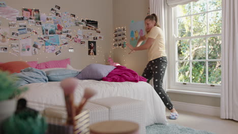 happy teenage girl dancing in bedroom having fun dance celebrating weekend feeling positive wearing pajamas at home