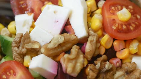 close-up of a fresh salad with vegetables, walnuts, and cheese