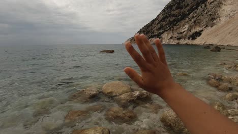 A-girl's-hand-waving-goodbye-at-the-sea