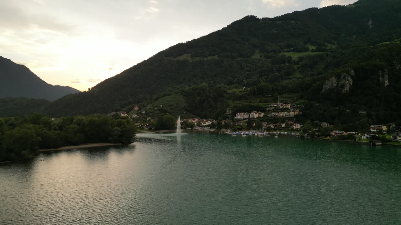 사람 들 을 위한 놀라운 자연 서식지 를 가진 멋진 자연 작은 도시 마을 나무 들 사이 에  ⁇ 인 언덕 에 있는 집 들 이 있는 도크 에 있는 배 들 은 높은 곳 에서 물 의 흐름 을 방출 하는 큰 분수  ⁇  에 서 있다