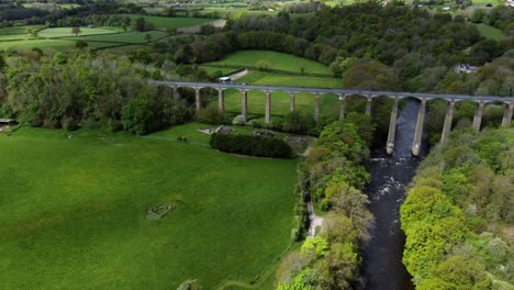 aerial view pontcysyllte aqueduct and river dee canal narrow boat bride in chirk welsh valley countryside dolly left