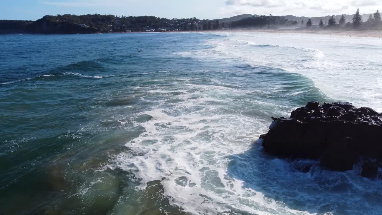 vista aérea del paisaje de drones de la escalada de surfistas saltando de rocas a las olas océano pacífico norte avoca nsw costa central 4k