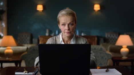 calm old woman working laptop at home