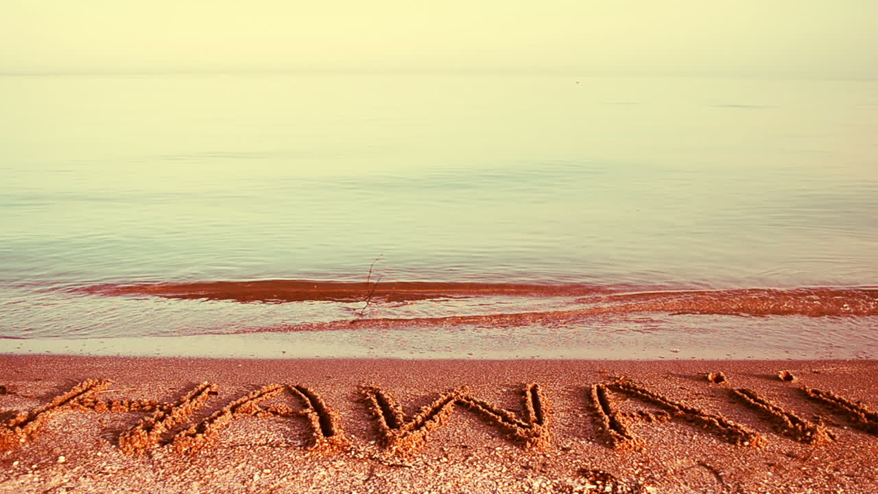 Inscription "Hawaii" made on beautiful beach. Inscription on sand, the beach