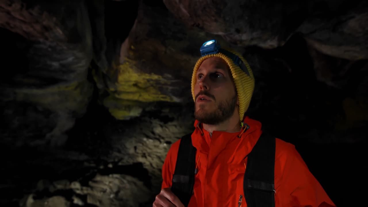 excursionista masculino explorando una cueva oscura 4k