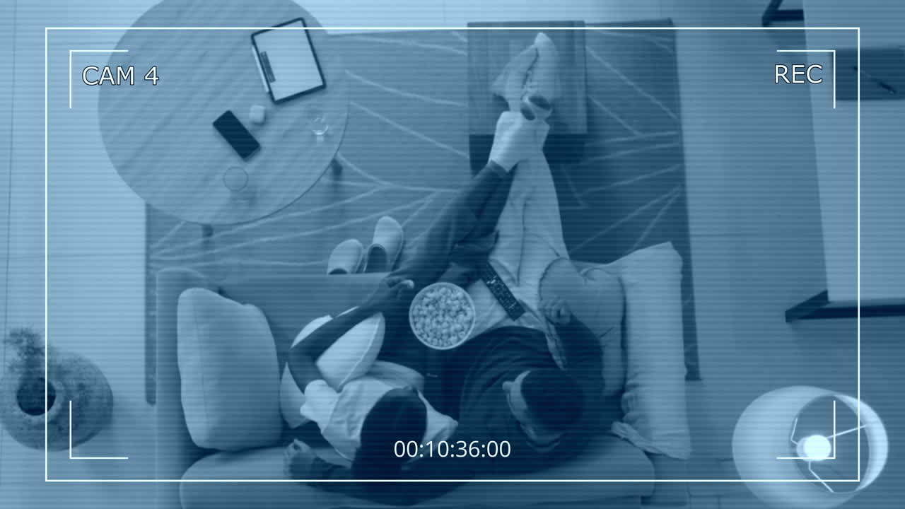 Spouses Watching TV and Eating Popcorn Hidden Camera Top Shot