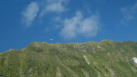 Maravilla-Aérea:-Avión-Volando-Debajo-De-La-Montaña-En-Milford-Sound-En-Un-Cautivador-Metraje-De-Archivo