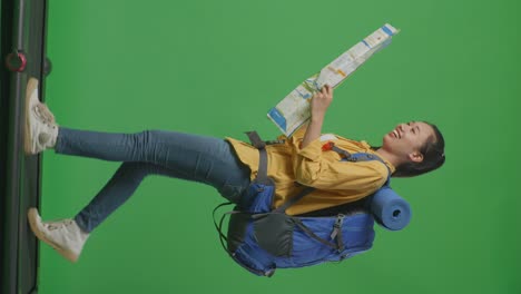 mujer con mochila y mapa en pantalla verde