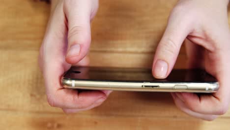 Businesswoman-using-mobile-phone-at-desk