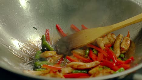 cook prepares fresh vegetables in a frying pan in boiling oil stir with a wooden spatula 2