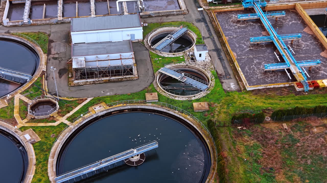 Aerial view of secondary clarifiers and technical buildings. Detail of circular sedimentation tanks and pumping stations at a modern treatment plant