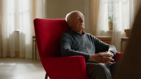elderly man relaxing in a red chair