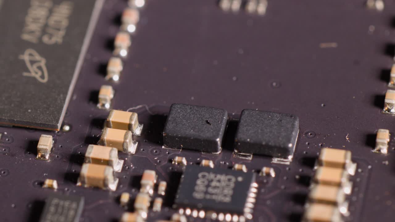 Macro camera movement pans across a computer RAM module circuit board with microchips and capacitors