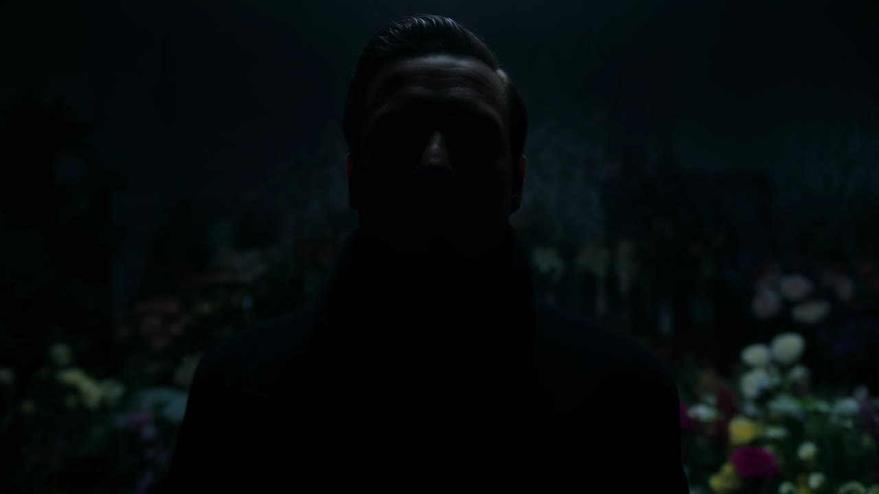 Uomo misterioso in silhouette contro uno sfondo floreale scuro