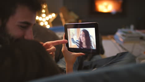 una pareja feliz saludando a un amigo durante un video
