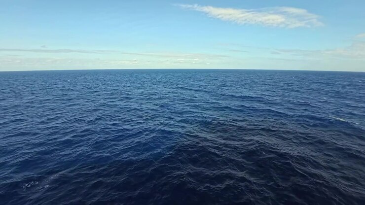 Vasto oceano blu con onde dolci sotto un cielo sereno