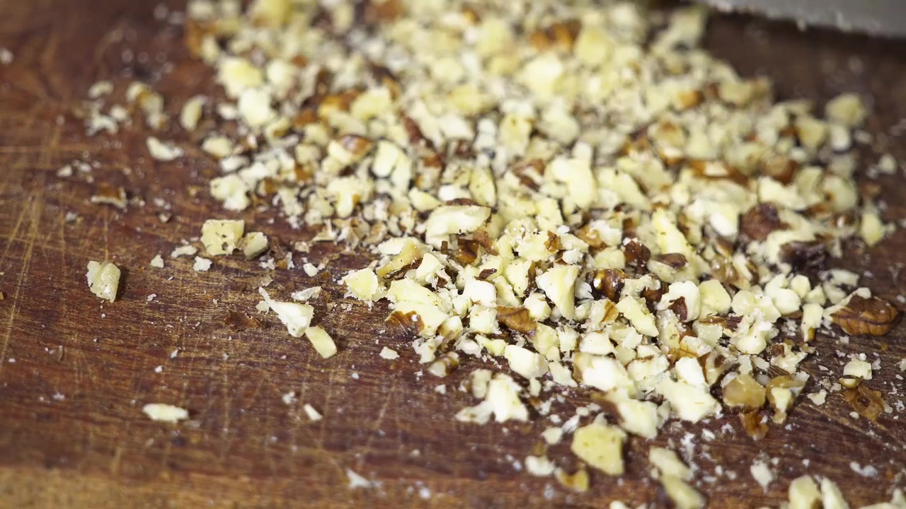 Primo piano di frutta secca tritata su un tavolo di legno.