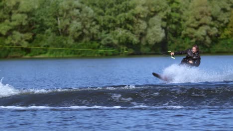 Junger-Mann-Hetzt-Auf-Dem-Wasserbrett-Auf-Dem-Wasser-Hinter-Dem-Motorboot.-Extremer-Wassersport