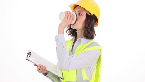 female construction engineer drinking coffee and reviewing documents
