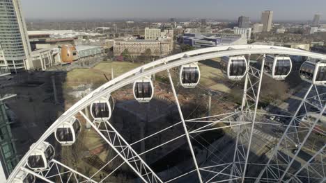 Drone approaches giant ferris wheel and looks over Atlanta Olympic Park