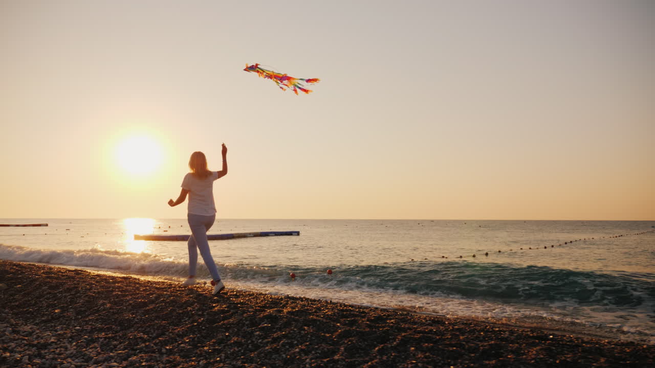 mujer con cometa corre a lo largo de la playa steadicam shot