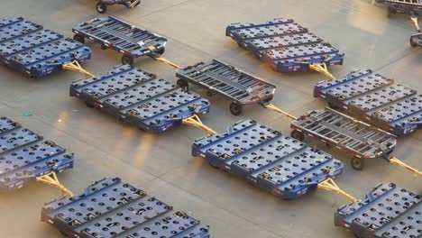 empty baggage carts lined up at airport on tarmac