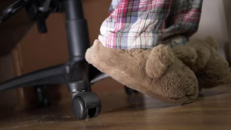 Feet-working-from-home-wearing-slippers-and-pyjamas-on-office-chair