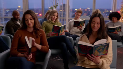 group of people reading books indoors