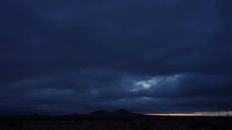 dark and stormy sunrise cloudscape over the mojave desert - night-to-day time lapse