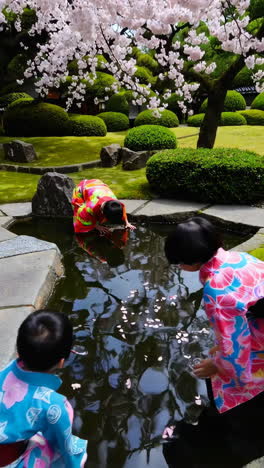children in kimono at a japanese garden with cherry blossoms