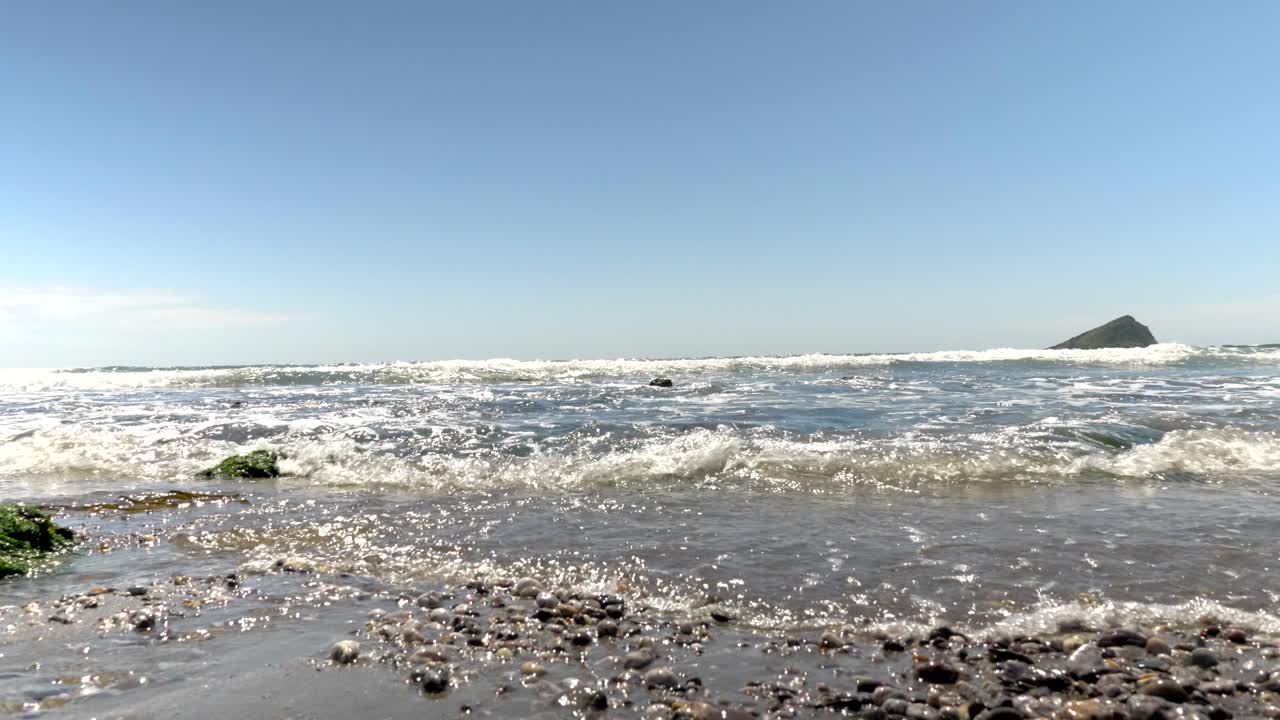 4K slow mo footage of rolling waves on a summer day off the Devon Coast. Beautiful, British summertime coastal footage.