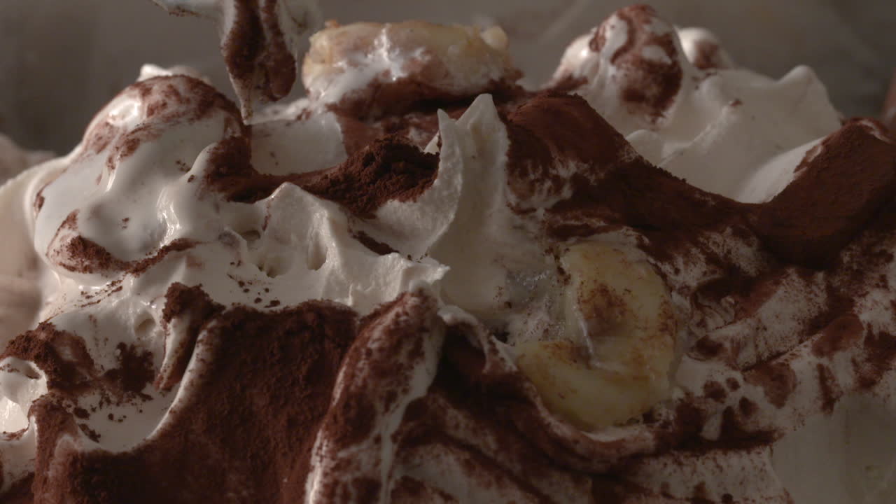 Mani con cucchiai colorati che mangiano gelato alla banana e vaniglia da un contenitore, time-lapse