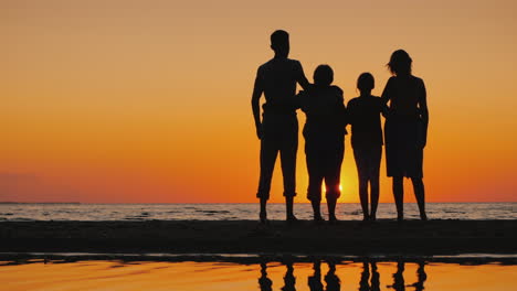 friendly multi-generational family together standing next to the sea looking at the horizon