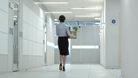 businesswoman walking with belongings to new office