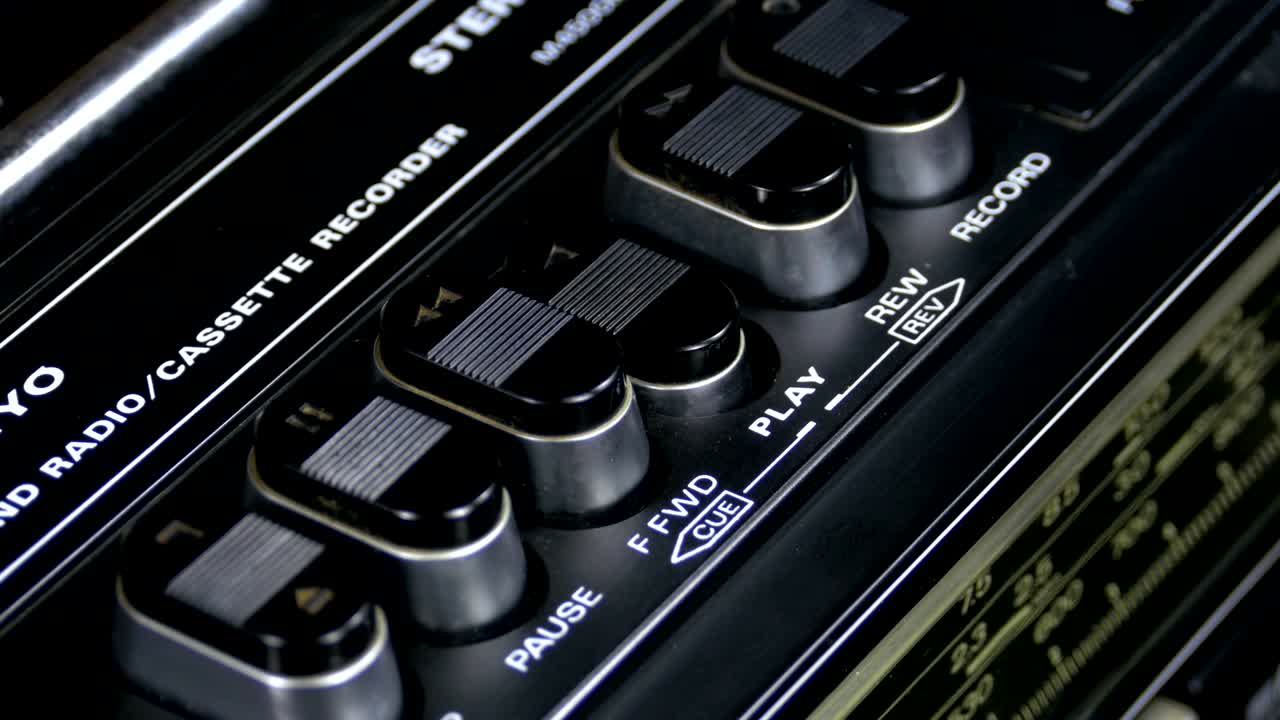 presionando el botón de un grabador de cinta, jugar, detener, grabar, ff, rew