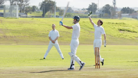 two teams of male cricket players playing cricket, bowler catching and throwing the ball on pitch