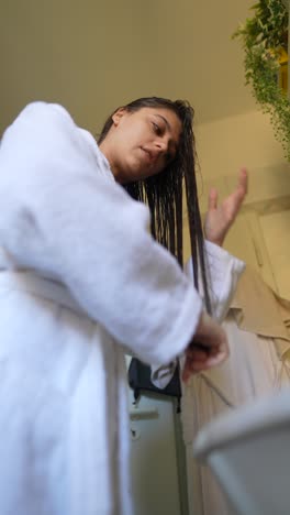 mujer secando el cabello en el baño