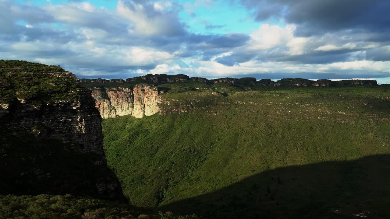 Tilting up shot revealing the stunning Capao Valley with large plateaus from the Mount of Pai Inácio hike in the Chapada Diamantina national park in northern Brazil on a warm summer evening