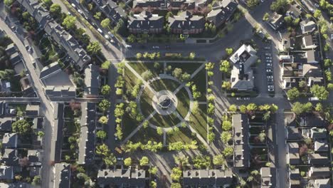 1-3-Vistas-Aéreas-De-Pájaros-Caen-Sobre-La-Glorieta-Del-Parque-De-La-Plaza-Del-Pueblo-Durante-La-Hora-Pico-De-La-Mañana-Mientras-Los-Estudiantes-Salen-A-La-Escuela-Y-Las-Personas-Empleadas-Salen-A-Trabajar-Durante-El-Bloqueo-Pandémico-Ignorado-En-Calgary-Ab