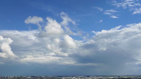 timelapse of cumulus floating clouds against blue sky with miniature city view