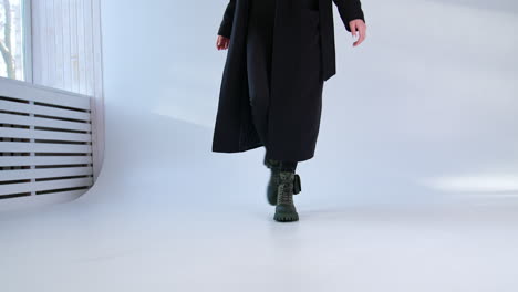 woman in black coat and green boots