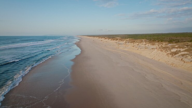 Strand bei Sonnenuntergang mit ruhiger See.